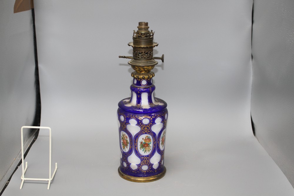 A Bohemian blue overlaid glass oil lamp base, painted with flowers, overall height 42.5cm